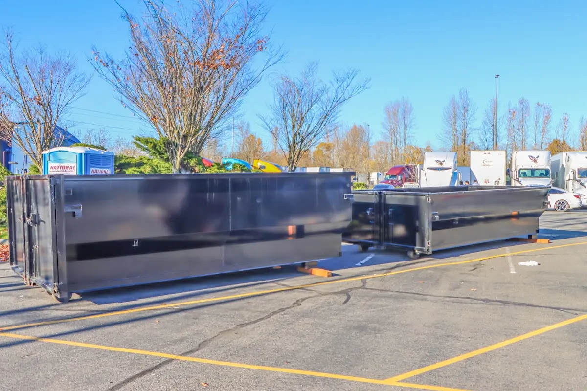 Professional dumpster rental service with roll-off container on residential driveway in Haddon